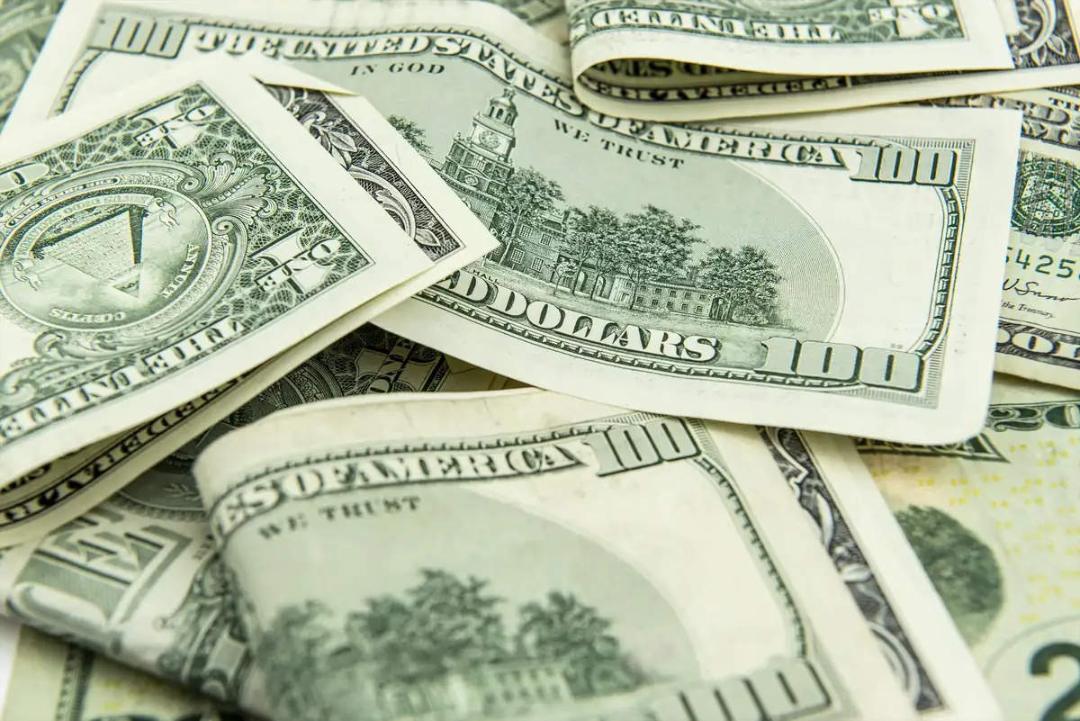 Billetes de dólar estadounidense extendidos sobre una superficie