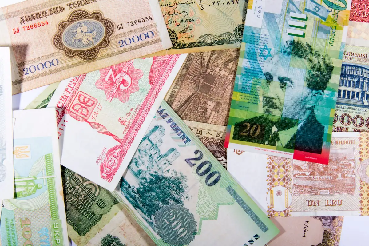 Banknotes from different countries spread across a surface